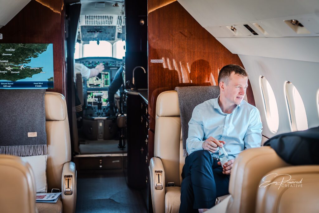 SwiftWings client relaxing with a drink aboard a luxury private jet charter.